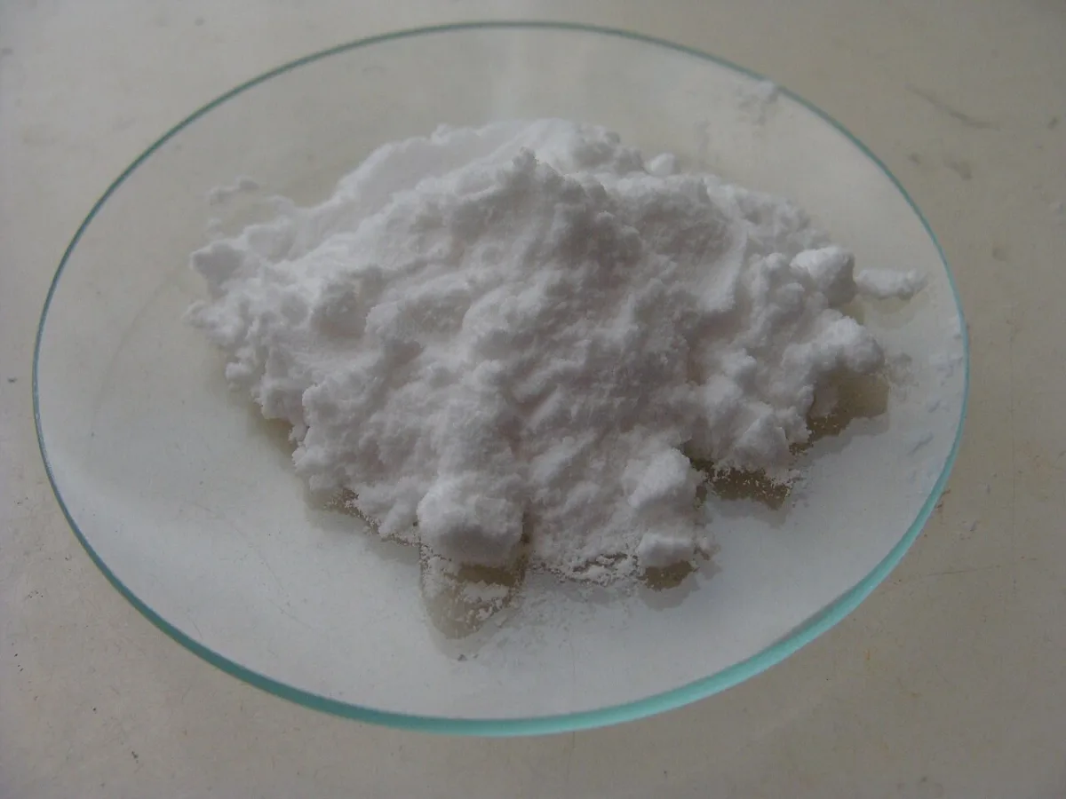 Hoopje wit poeder (baking soda) op een glazen schaaltje
